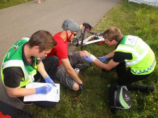 Patient being helped by SJA Medical First Responders after falling from his bike.
