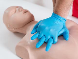 CPR on a manikin with blue gloves